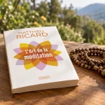 Le livre L'Art de la méditation, de Matthieu Ricard, posé sur une table en bois